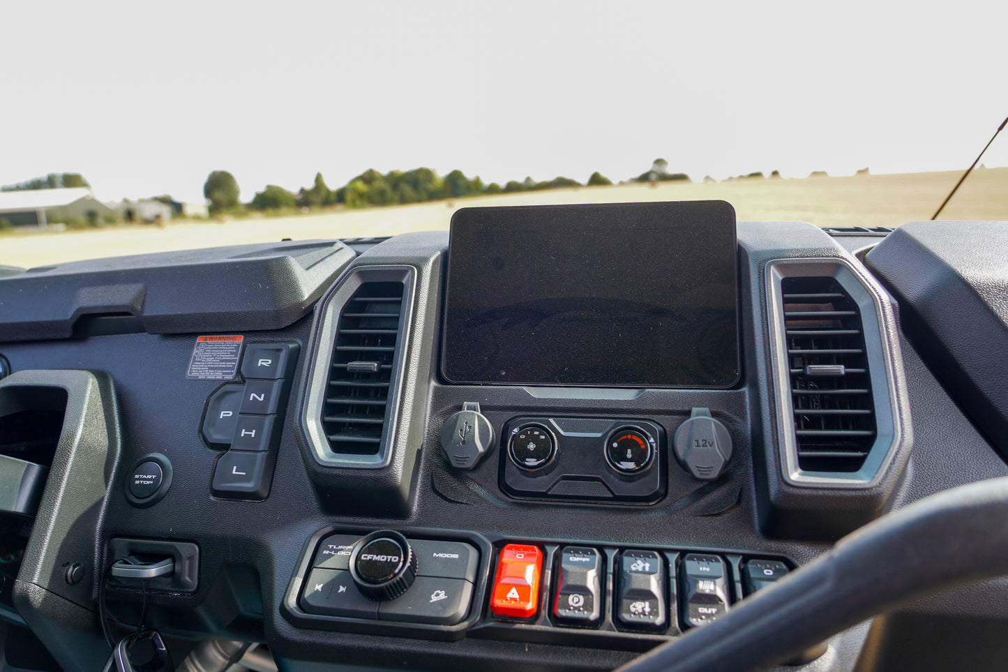 Close-up of a CFMOTO U10 Pro dashboard with controls and a screen.