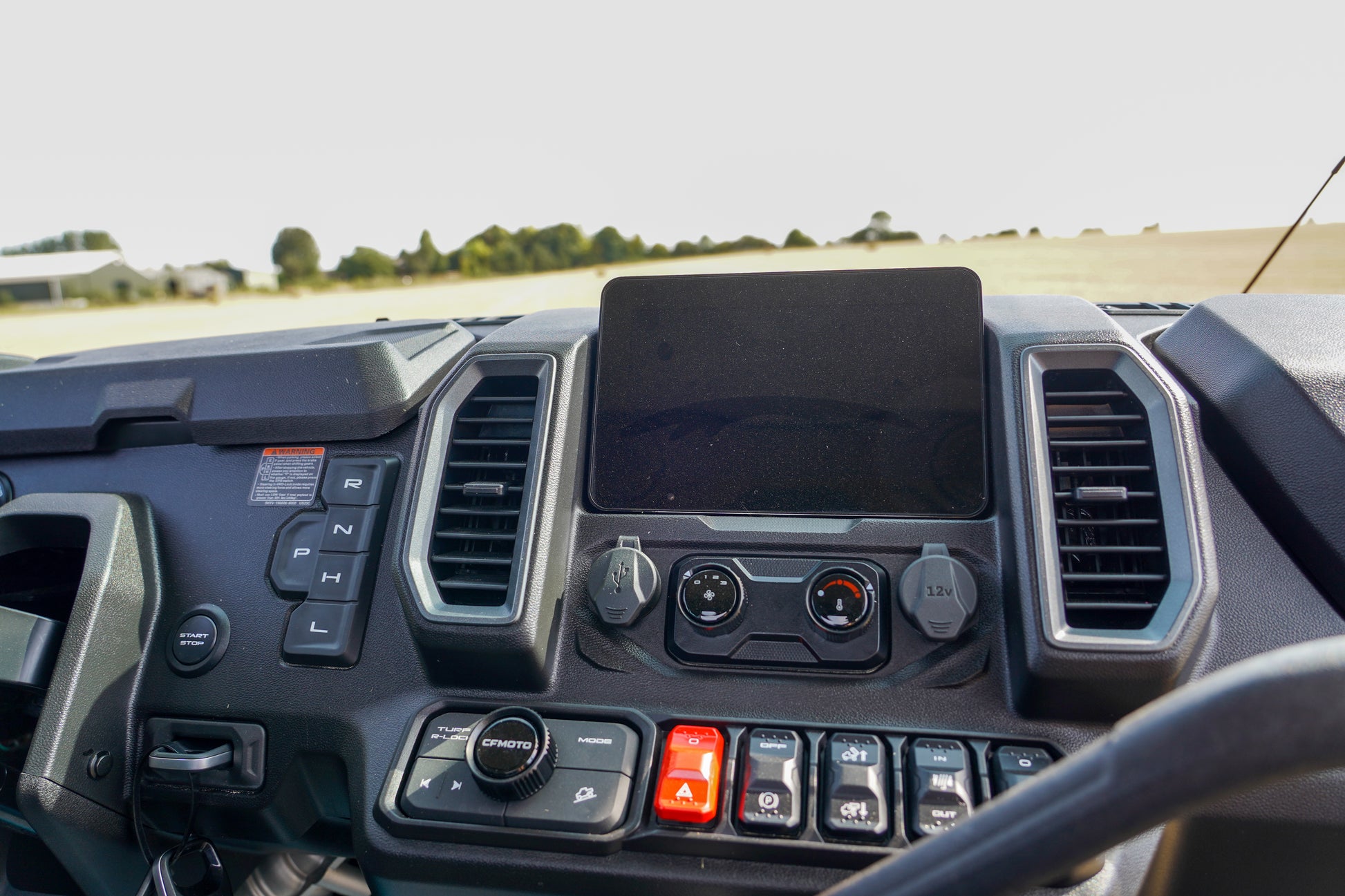 Close-up of a CFMOTO U10 Pro dashboard with controls and a screen.
