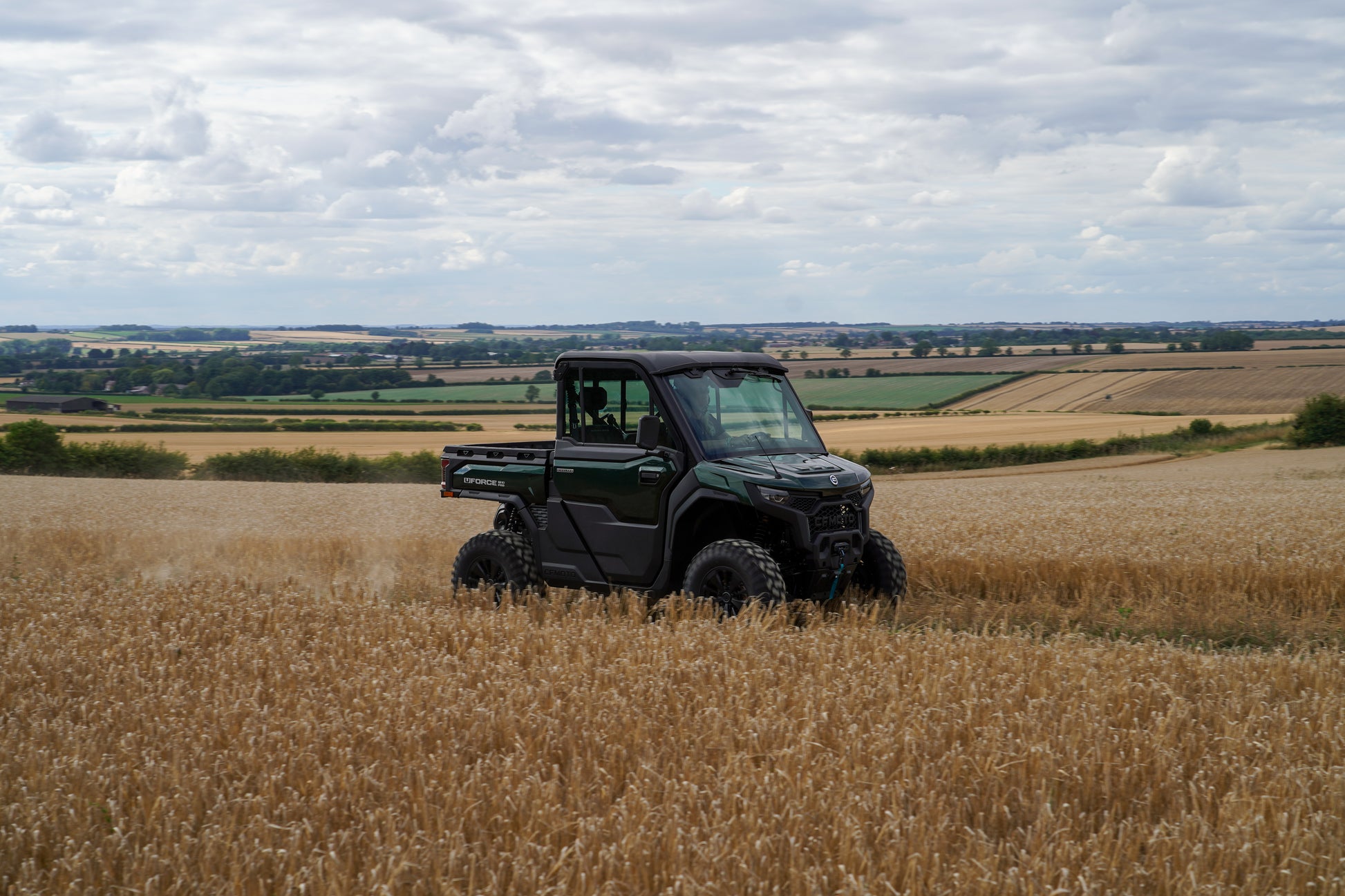 CFMOTO U10 Pro off-road vehicle in a wheat field with a cloudy sky