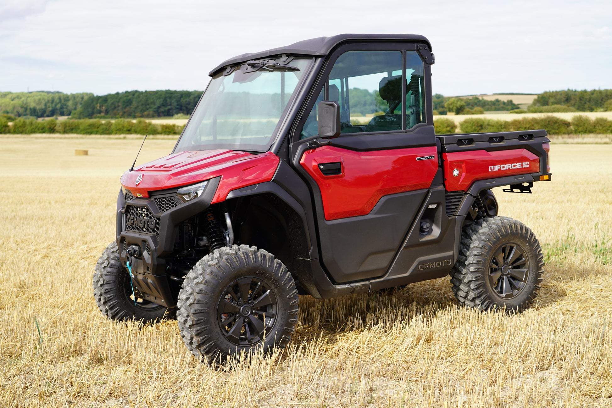 Red CFMOTO U10 Pro UTV in a field with a clear sky