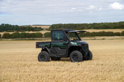 Green CFMOTO U10 Pro utility vehicle in a field with a rural landscape in the background
