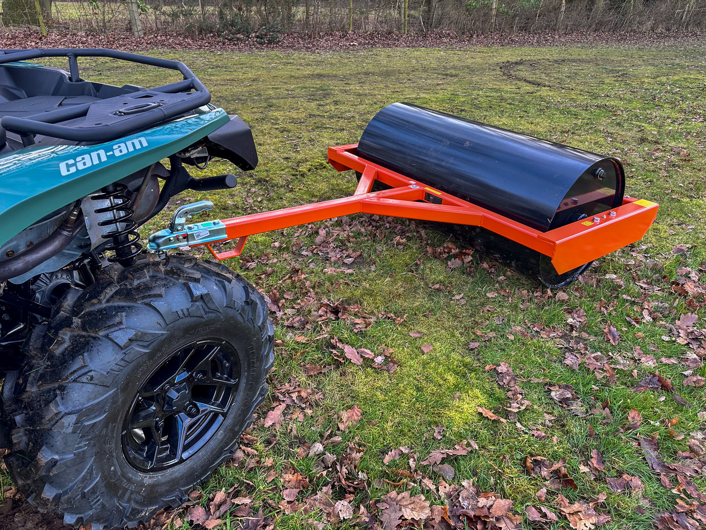 Can-Am ATV with a FarmMaster land roller attached on a grassy field