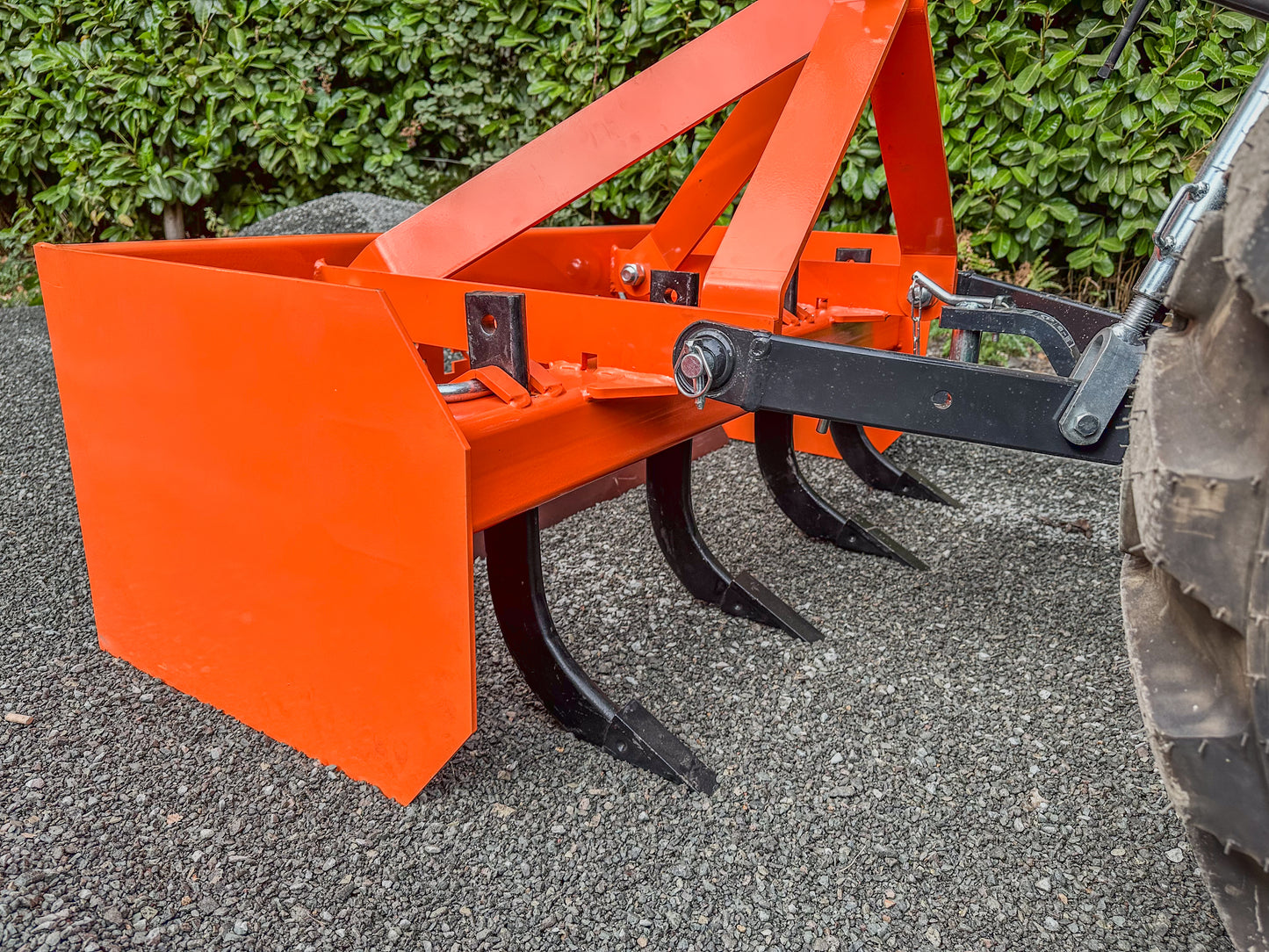 FarmMaster tractor box grader on gravel surface with greenery in the background