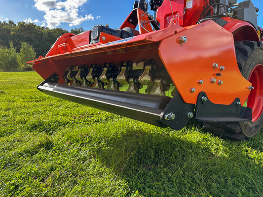 FarmMaster Flail Mower on a grassy field with trees and blue sky in the background