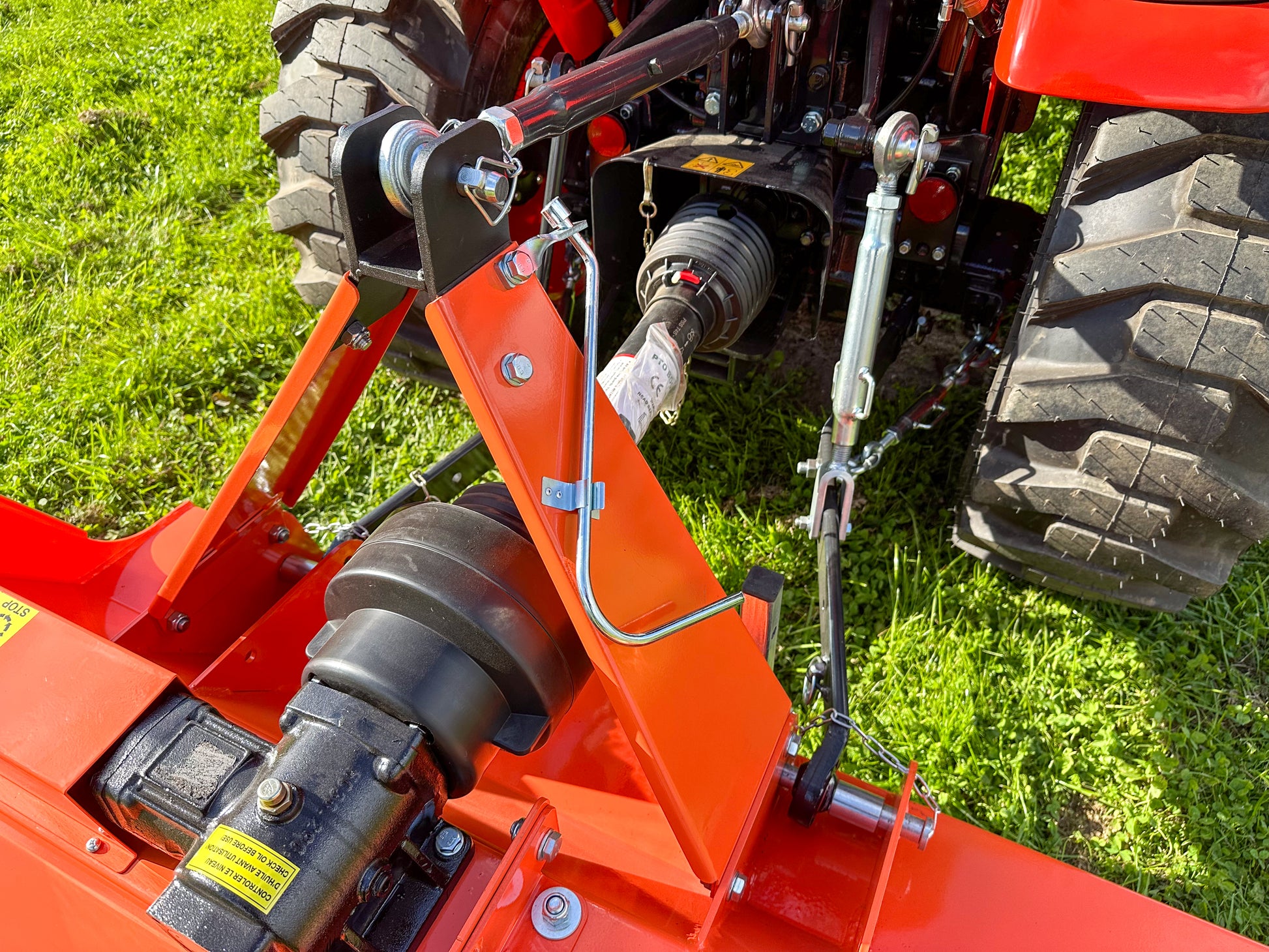 Close-up of a red agricultural tractor with a FarmMaster flail mower