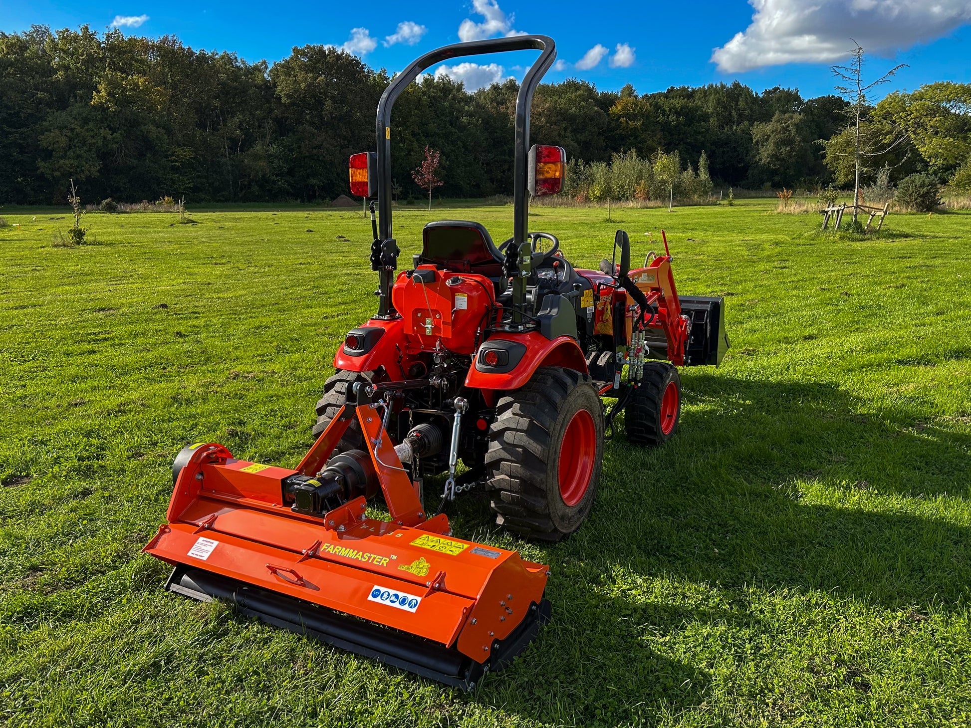 Kioti tractor with a FarmMaster flail mower attachment on a grassy field