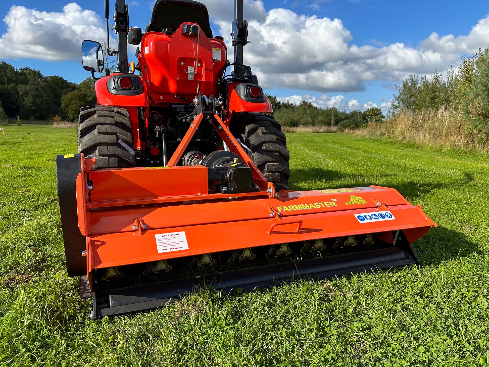 Kioti tractor with a FarmMaster flail mower attachment on a grassy field