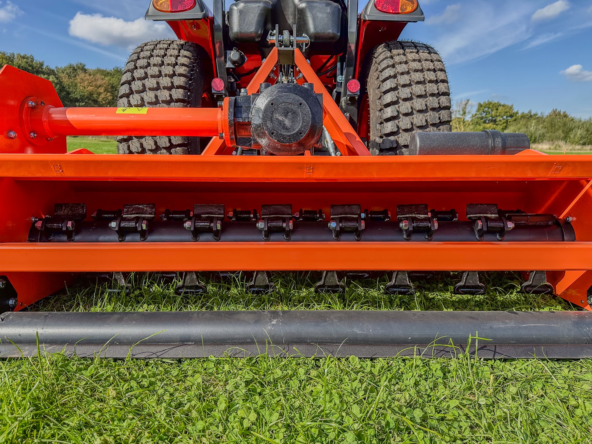 Close-up of a FarmMaster tractor flail mower on grass