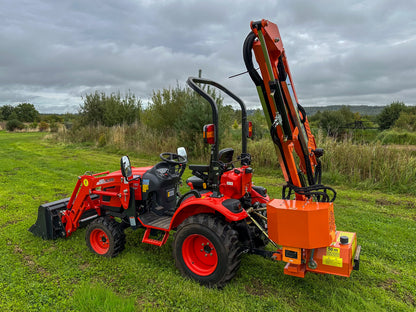 Kioti tractor with a FarmMaster tractor hedge cutter in a grassy field on a cloudy day