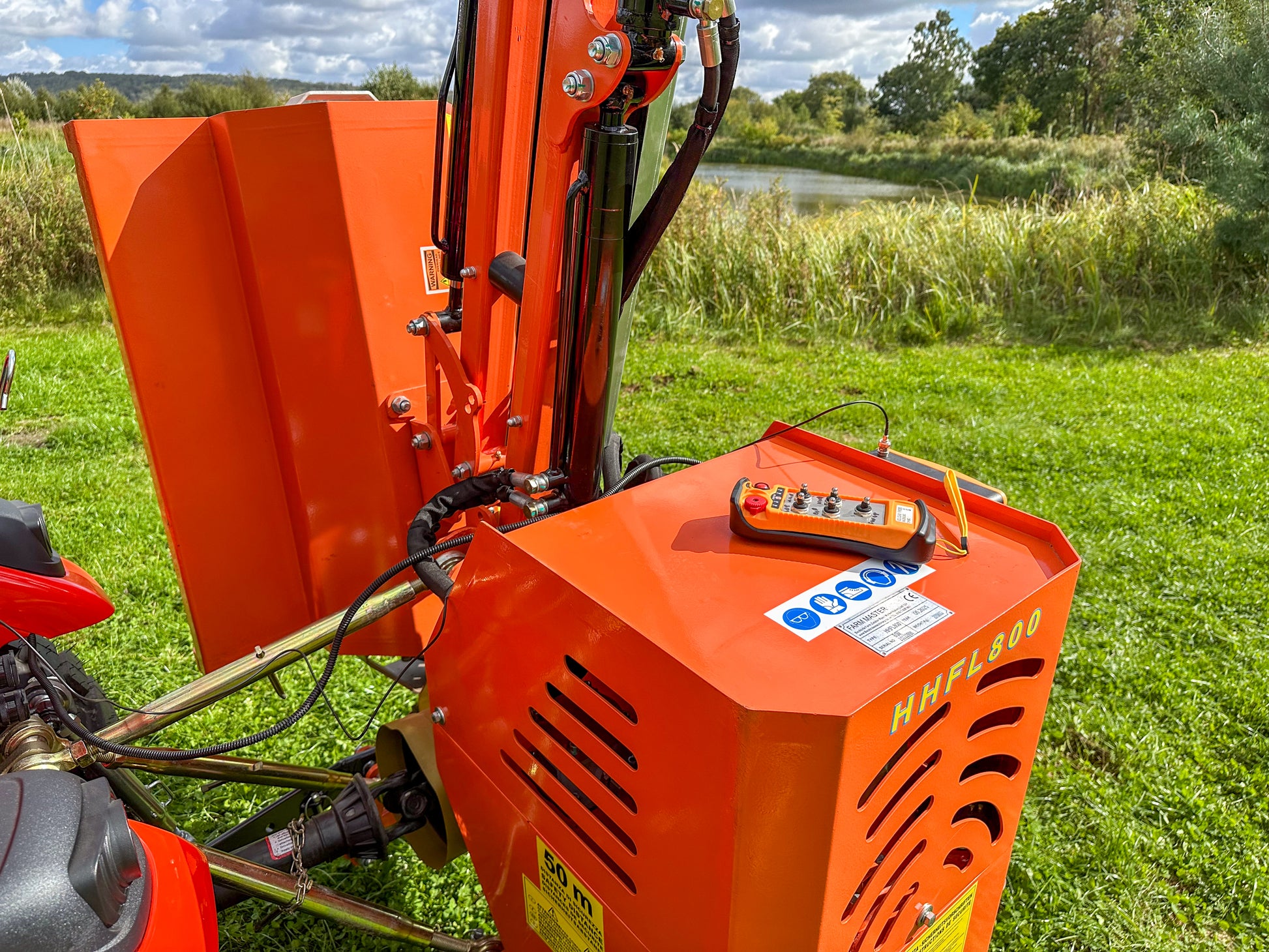 FarmMaster tractor hedge cutter with control panel on a grassy field