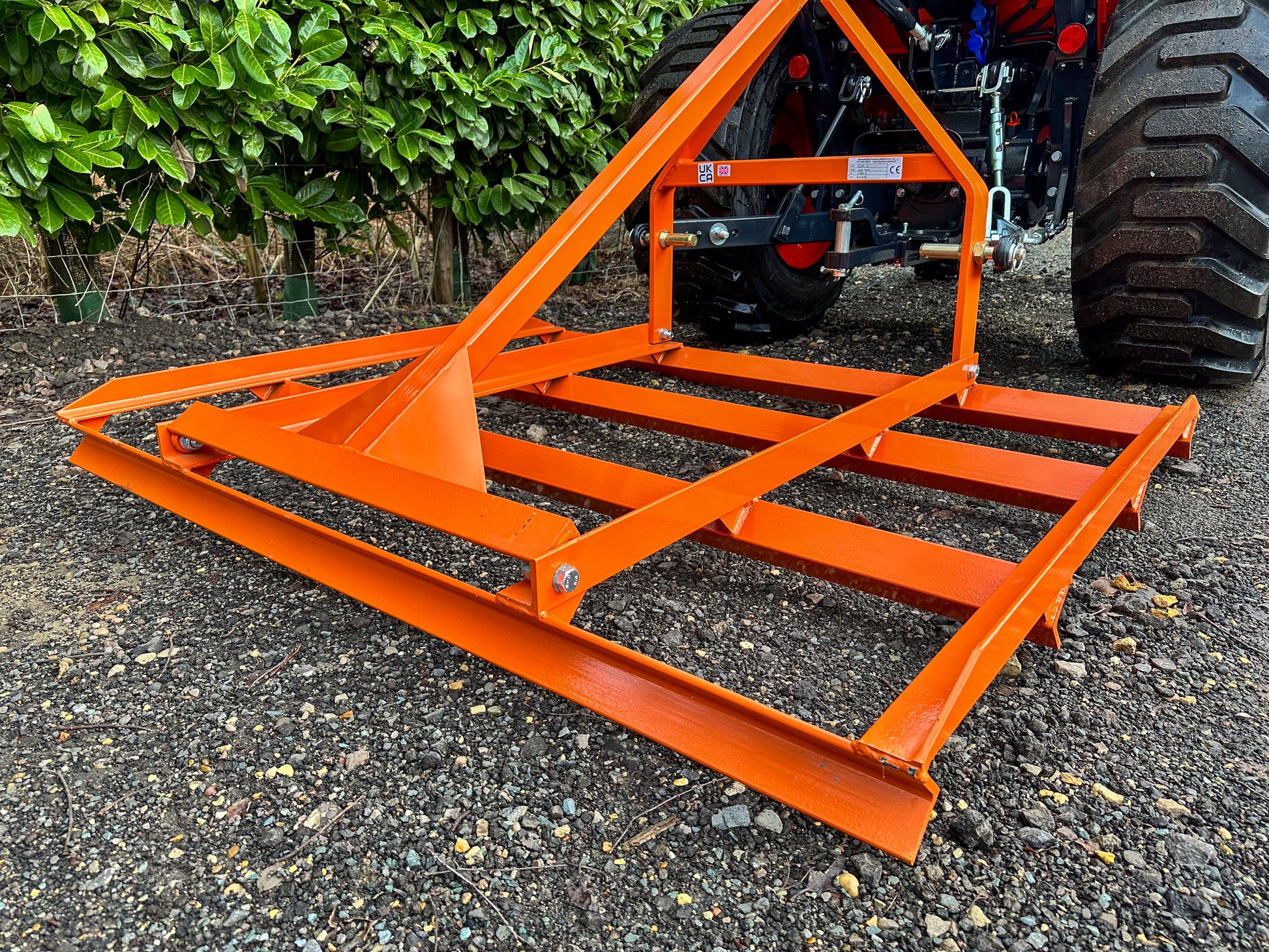 FarmMaster tractor leveller on a gravel surface with greenery in the background