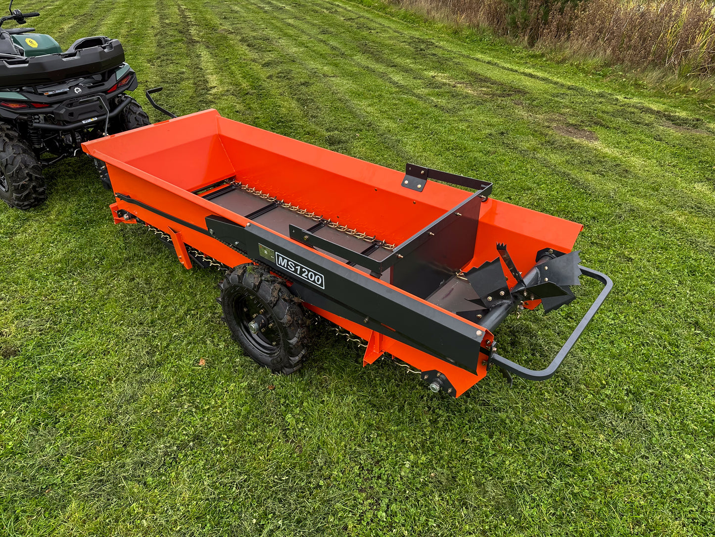 FarmMaster muck spreader with a ATV in the background