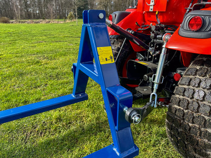 FarmMaster tractor pallet forks attached to a Kioti tractor on a grassy field
