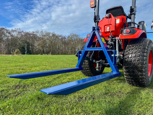 Kioti tractor with a FarmMaster tractor pallet forks on a grassy field