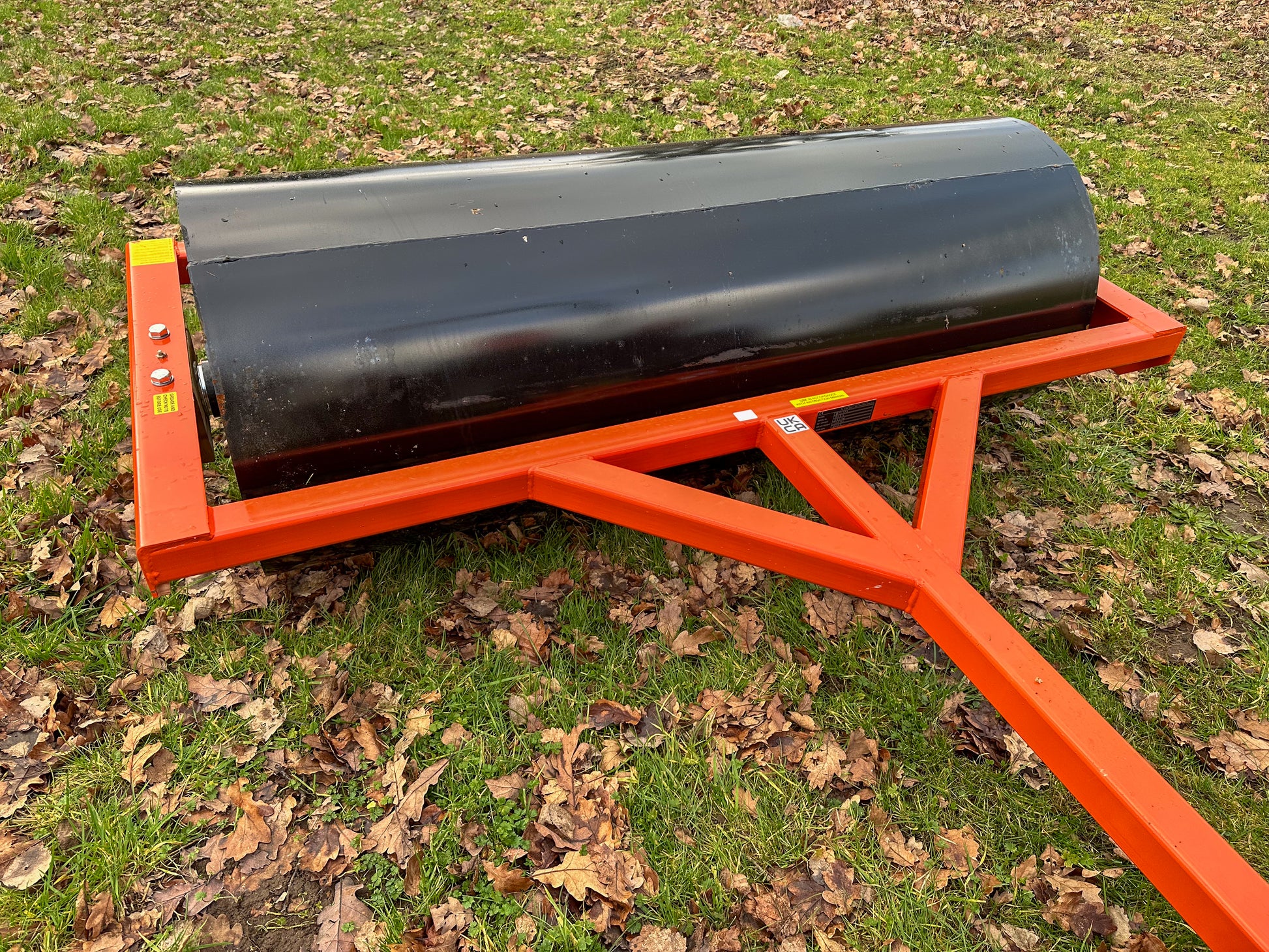 FarmMaster tractor land roller in a grassy area with fallen leaves.