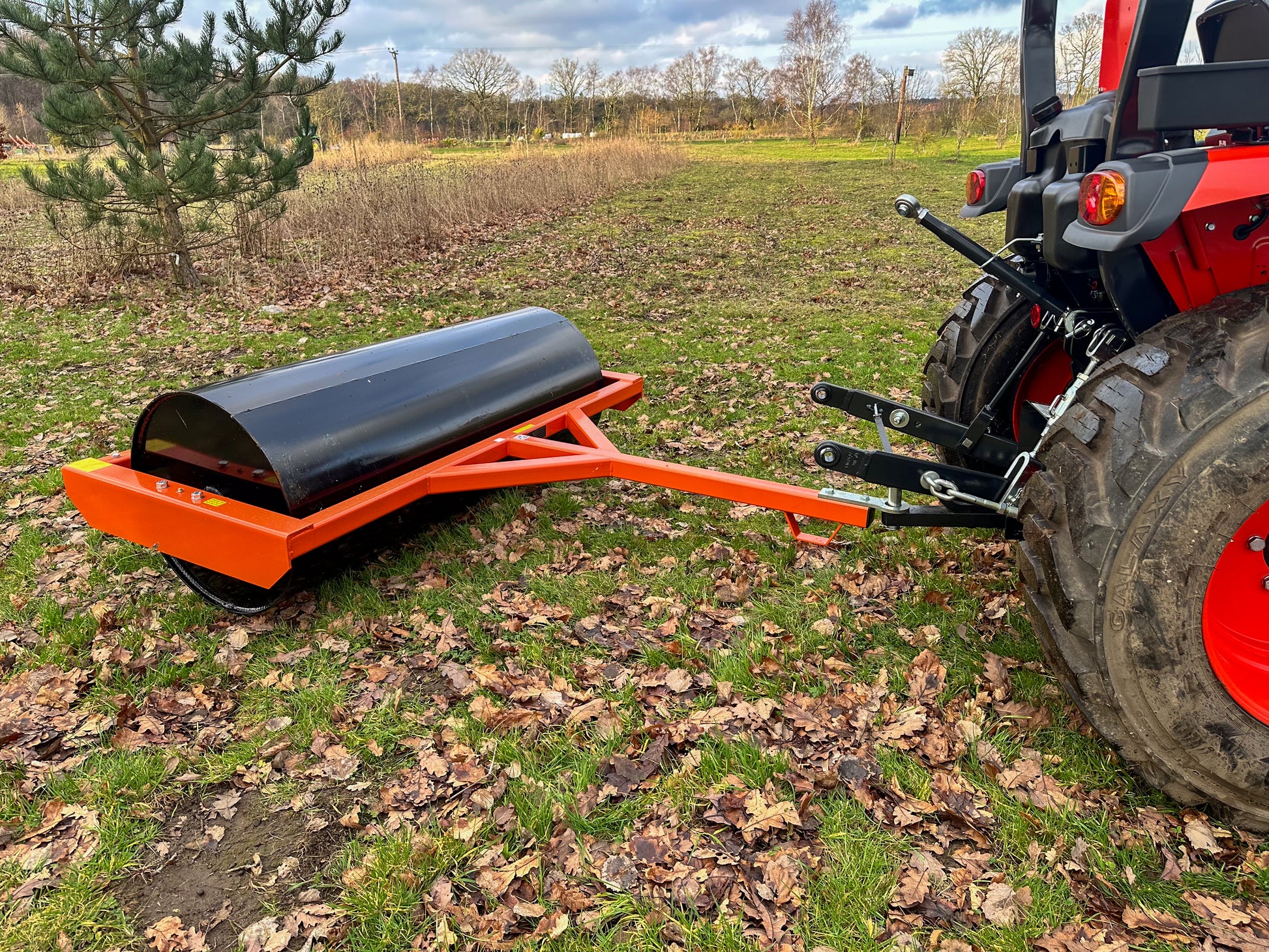 Tractor with a FarmMaster tractor land roller on a grassy field