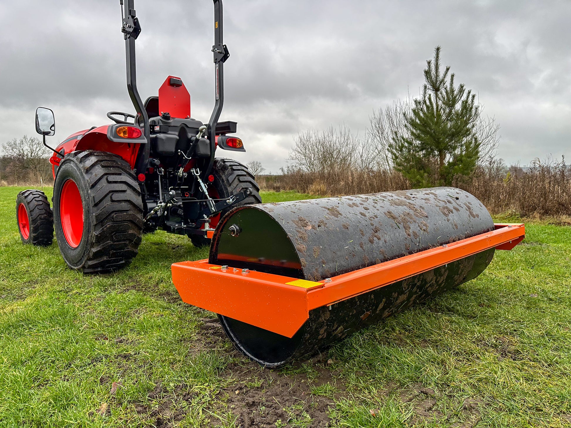 Tractor with a FarmMaster tractor land roller on a grassy field
