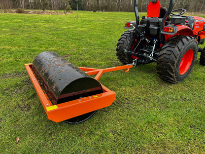 Red tractor pulling a FarmMaster tractor land roller on a grassy field
