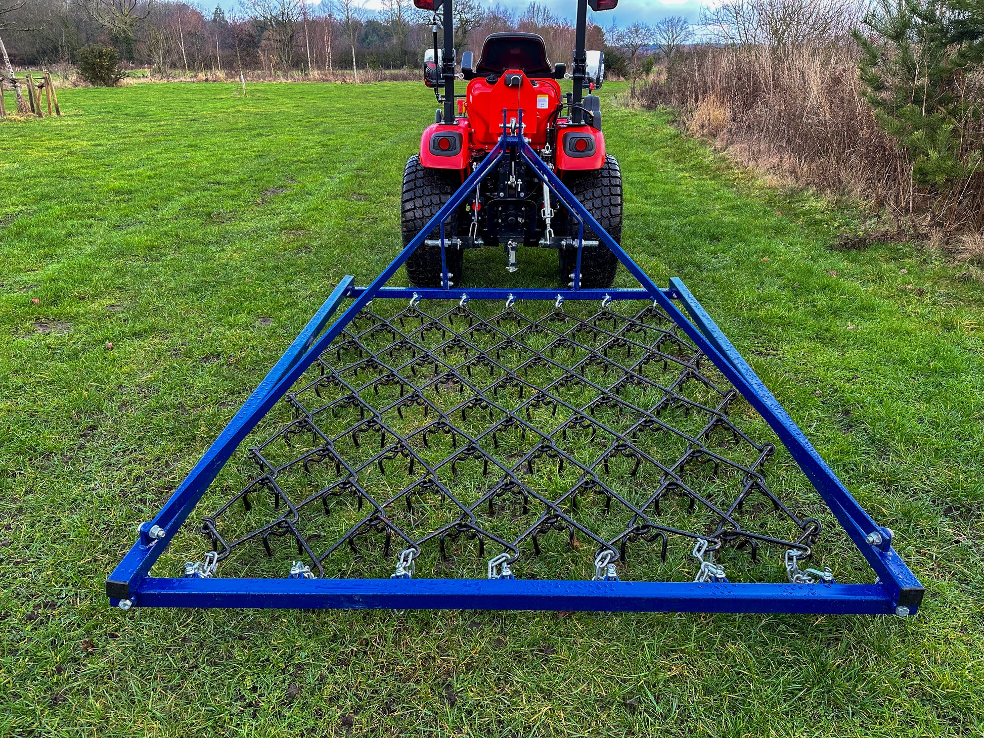 FarmMaster Framed Chain Harrow attached to a Kioti tractor on a grassy field