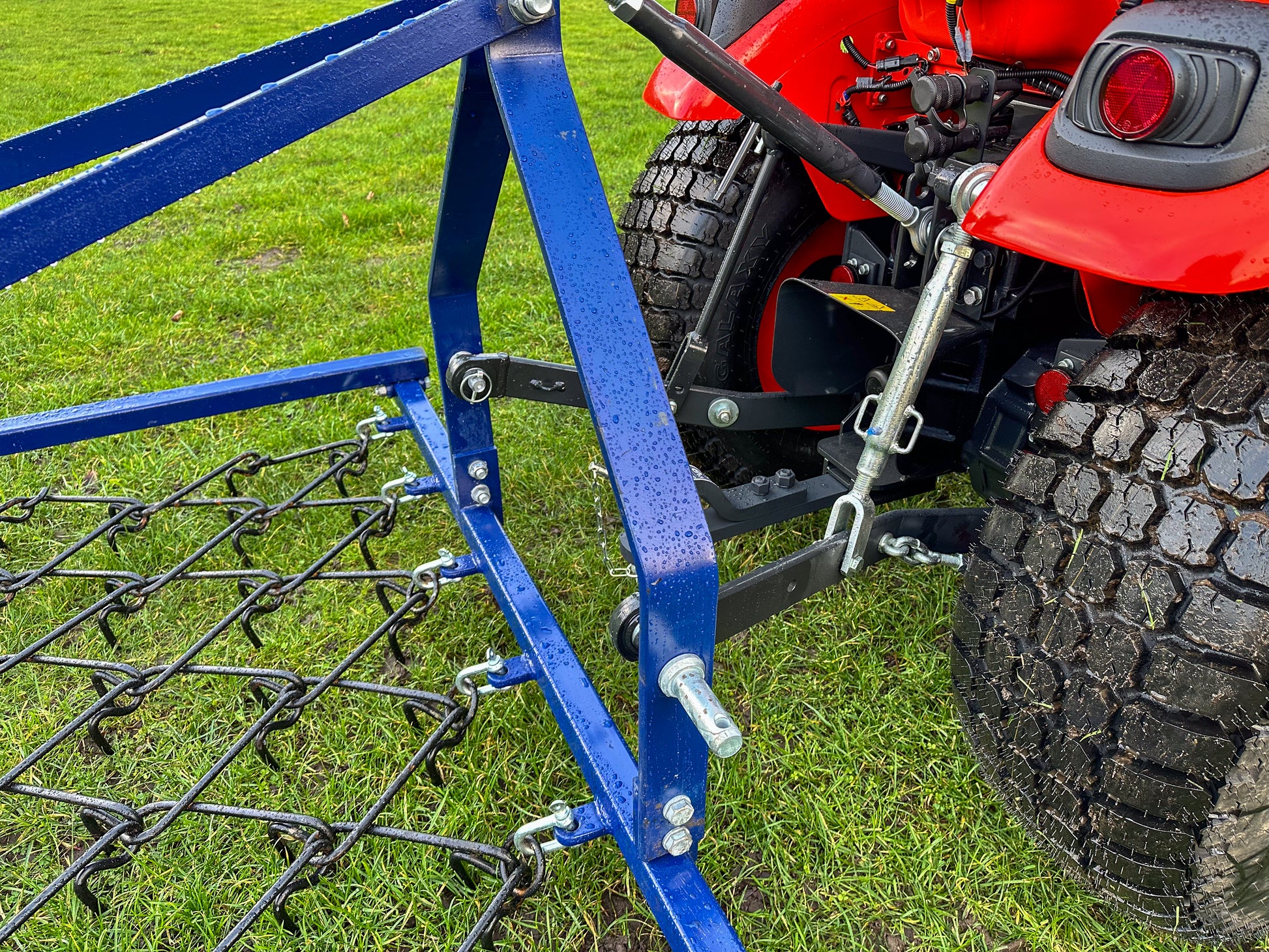 Kioti tractor with a FarmMaster Framed Chain Harrow on a grassy field