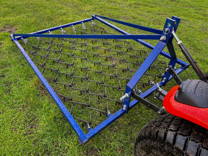 FarmMaster Framed Chain Harrow attached to a red tractor on grass