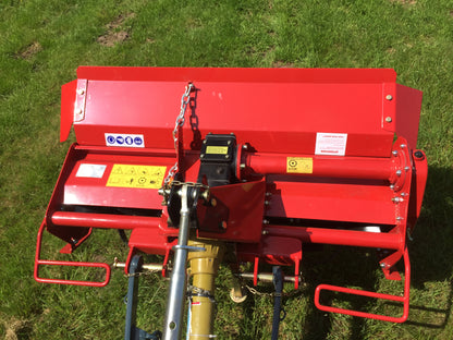 Red tractor rotavator on a grassy field