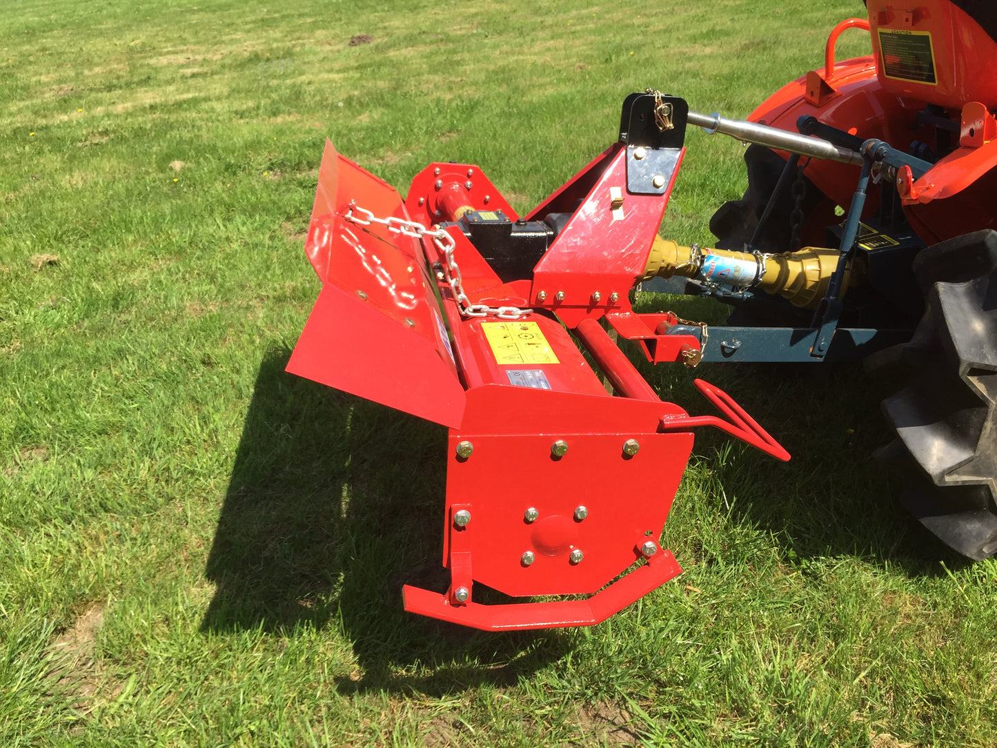 FarmMaster tractor rotavator attachment on a tractor in a grassy field