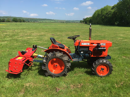 Kubota tractor with a FarmMaster tractor rotavator attachment in a grassy field.