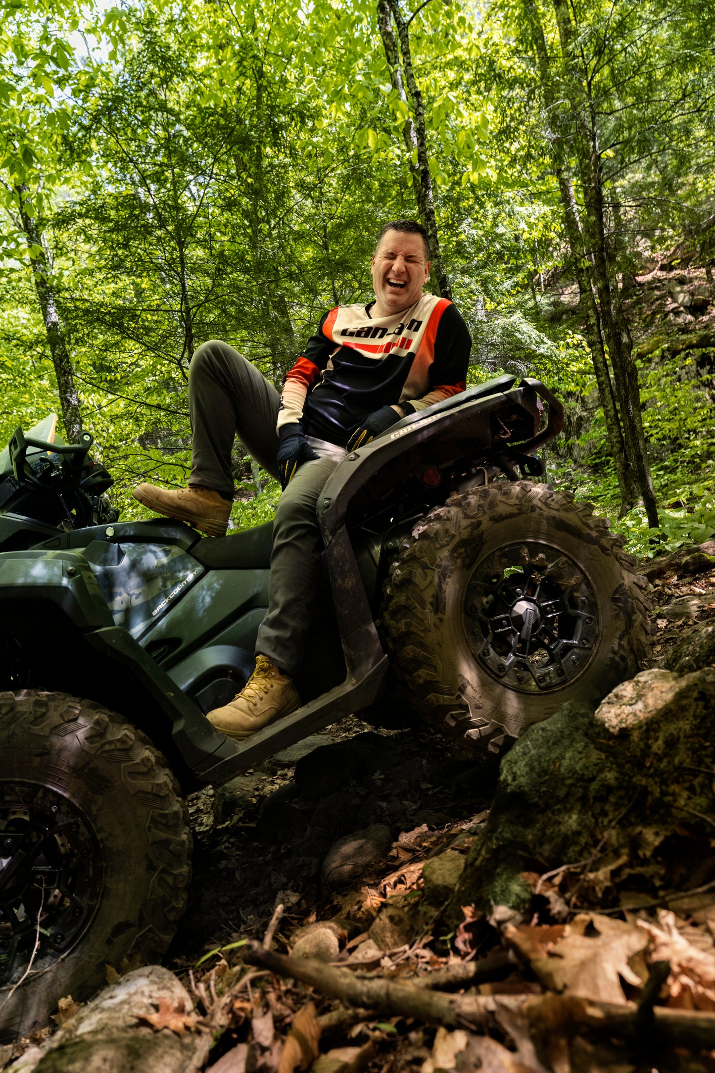 Person riding a Can-Am ATV through a forest