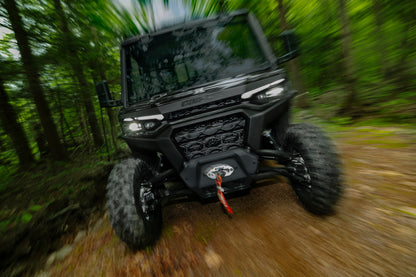 Black Can-Am Traxter UTV driving through a forest