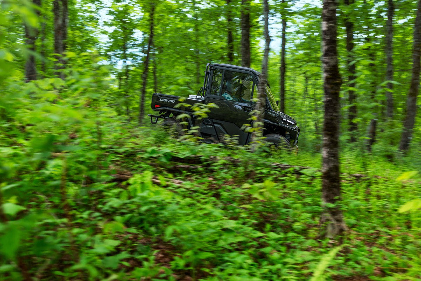 Can-Am Traxter Utility vehicle navigating through a dense forest