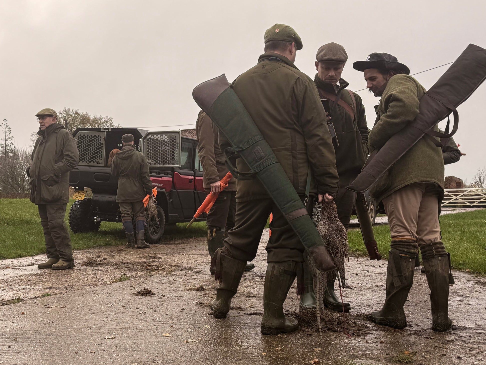 Group of hunters on a hunt with shotguns and equipment on a muddy path with a CFMOTO UTV in the background