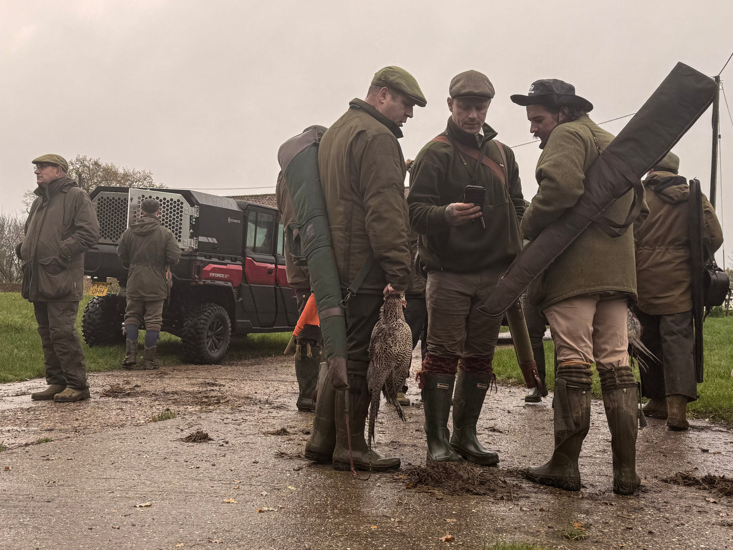 Group of hunters in outdoor clothing with a CFMOTO UTV vehicle and equipment in the background