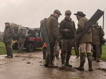 Group of hunters in outdoor clothing with a CFMOTO UTV vehicle and equipment in the background