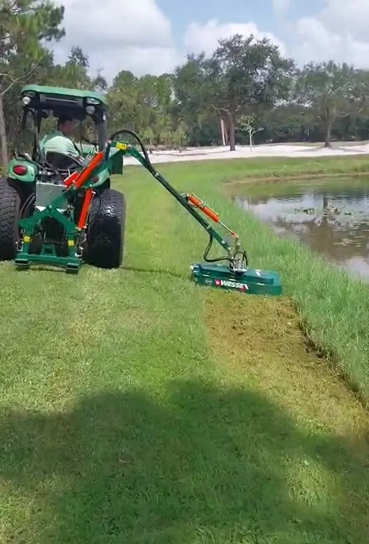 Tractor with a Wessex hedge cutter attachment working on a grassy area near a pond.