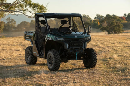 CFMOTO U10 Pro Utility vehicle in a field with trees and mountains in the background