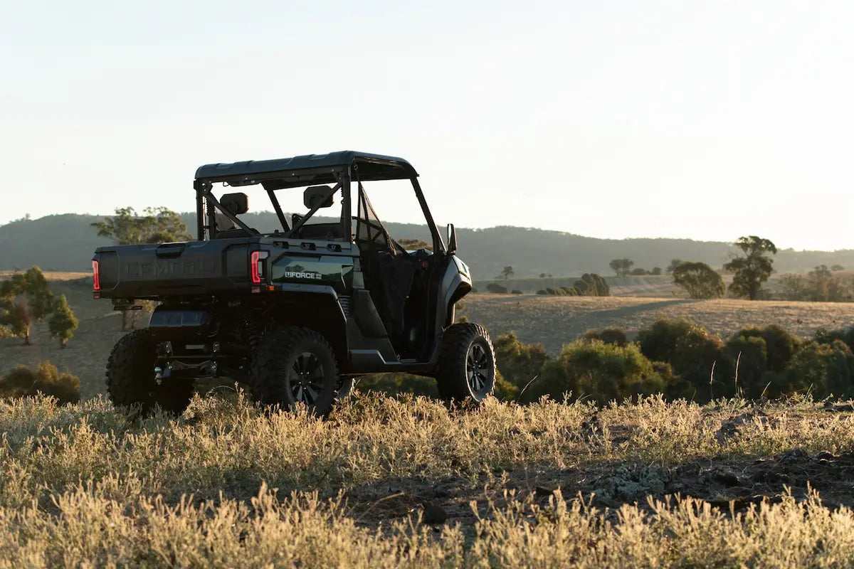 CFMOTO U10 Pro UTV in a field with trees and mountains in the background