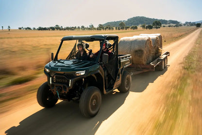 CFMOTO U10 Pro UTV with a trailer carrying hay bales on a dirt road.