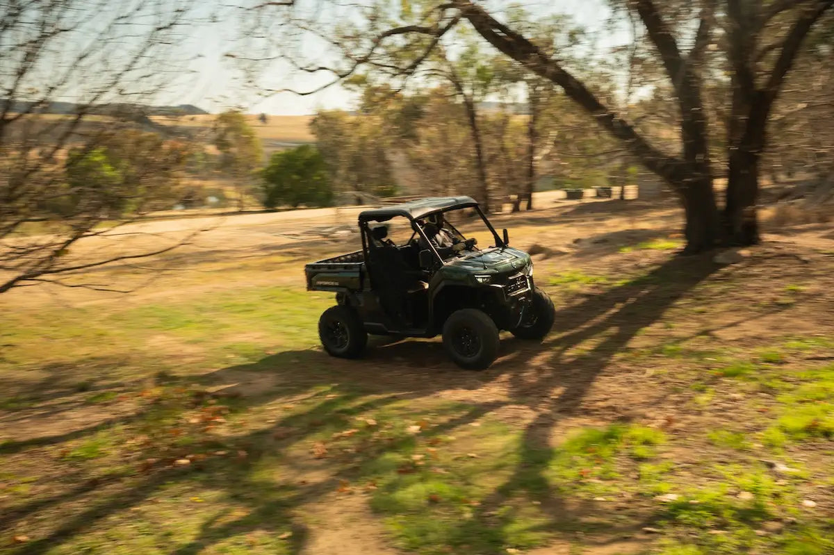 CFMOTO U10 Pro UTV on a dirt path in a natural landscape with trees and open fields.