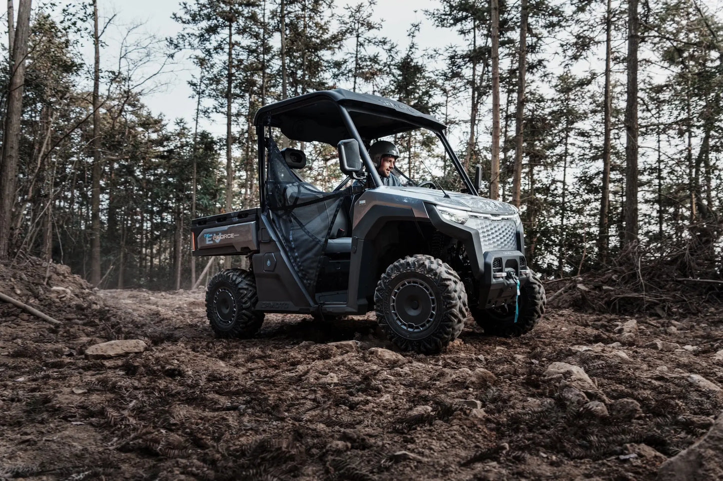 CFMOTO U6EV Electric UTV Utility vehicle driving through a forested area