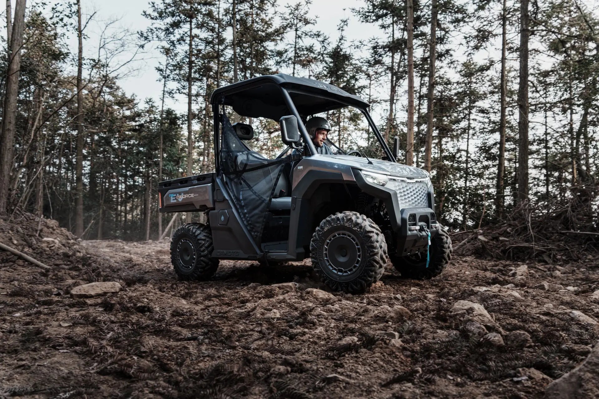 CFMOTO U6EV Electric UTV Utility vehicle driving through a forested area