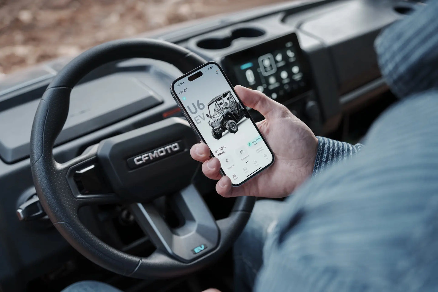 Person using a smartphone inside a CFMOTO U6EV Electric UTV