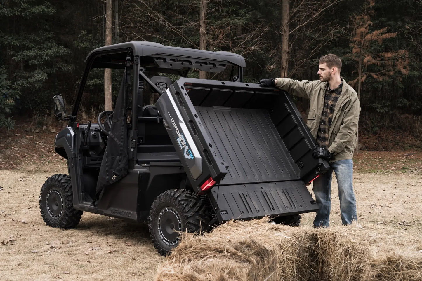 Person interacting with a CFMOTO U6EV Electric UTV in a forest setting