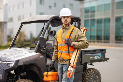 Person in safety gear standing next to a CFMOTO U6EV Electric UTV with construction tools, wearing an orange vest and hard hat.