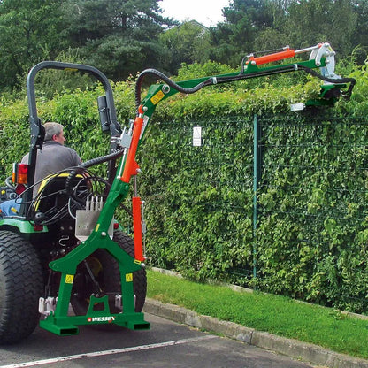 Tractor with a Wessex hedge cutter attachment cutting a hedge.