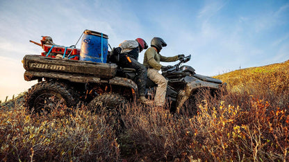 Person on a Can-Am Outlander 6x6 ATV in a field with a clear sky