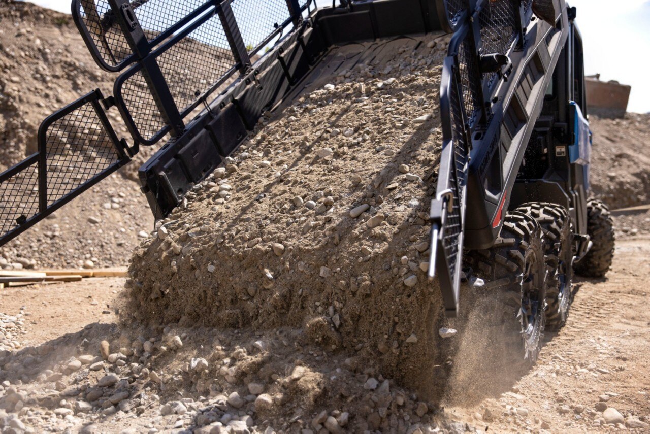Can-Am Traxter UTV with a bed carrying dirt on a construction site